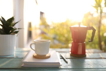 Coffee and moka pot and notebook on blue wooden table outdoor