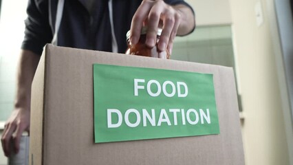 Filling a Donation Box With Food To Give Away at a Food Bank