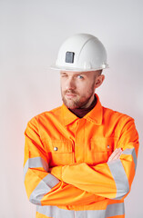 Attractive caucasian bearded construction site manager, supervisor or foreman in white hard hat and safety orange reflective vest. 1st of May or International Labor Day concept. High quality photo