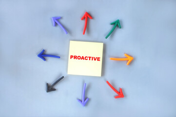 Proactive written on yellow sticky note with colorful arrow. Personal growth concept and mindset idea