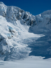 Snowcapped mountain ridgeline, crevasses and hanging glaciers in the Alaska Range