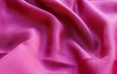 Red silk or satin luxury fabric texture can use as abstract background. Top view.
