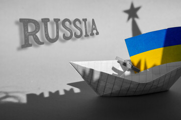 paper ships with flag of of Ukraine and Kremlin star Russia, relationships war conflict between the...