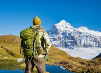 Tourist with a backpack in the mountains. Mountain hiking in the high mountains. Travel and adventure. Active life. Landscape in the summertime. Photo with high resolution.