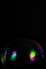 Close-up of a soap bubble on black background, free space