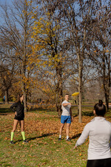 Naklejka premium Three friends playing frisbee and having a fun time together in the park