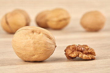 Whole walnut together with peeled walnut on a wooden background