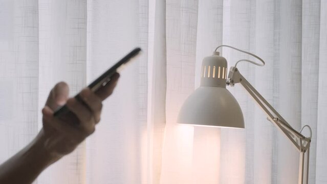 App on mobile phone controls light bulbs in smart home to turn off and turn on with hand