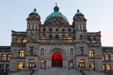 Fototapeta na wymiar The 1897 British Columbia Parliament building’s main entrance seen at dusk with red lanterns hanging to highlight the Chinese New Year, Victoria, BC, Canada
