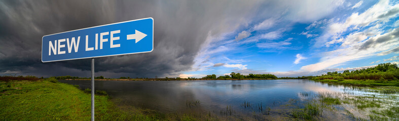 Fototapeta na wymiar New Life sign on background of amazing landscape nature before thunder storm. Dark clouds cover blue sky at wild river. Incredible weather panorama