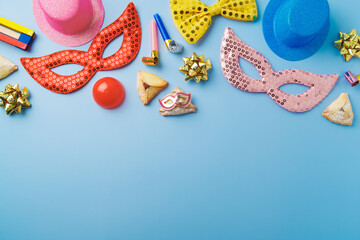 Purim holiday concept with carnival mask, noisemaker, hamantaschen cookies and party supplies on...