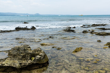 Fototapeta na wymiar Sea splash over the rock and stone beach