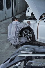 Car service worker repairs restores car