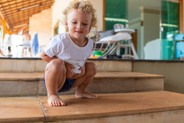 Child squatting on a ladder, blurred background