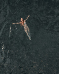 Girl swims relaxed in a beautiful mountain lake