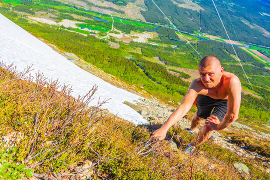 Extreme hiker hikes climbs in snow in summer Hemsedal Norway.