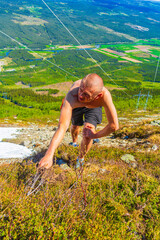 Extreme hiker hikes climbs in snow in summer Hemsedal Norway.