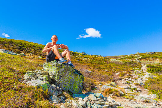 Male extreme hiker traveler on huge rock boulder Norway Hemsedal.