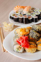 A variety of rolls and sushi on a white plate. Vertical photo.