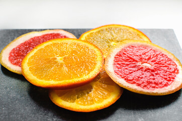 Naklejka na ściany i meble Sliced citrus fruits on a neutral background. Oranges and grapefruits, close-up.