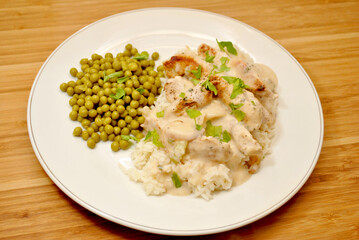 Pork with Cream Sauce Over White Rice & a Side Dish of Peas	