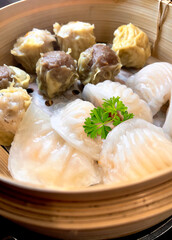 variety of steamed dim sum, in a bamboo box
