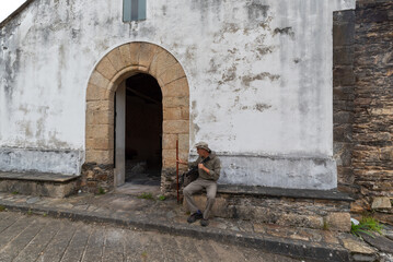 Pilgrim walking on the Camino de Santiago, at the door of the church. Way of St James
