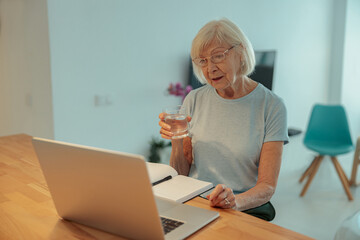 Senior woman looking at laptop screen indoors