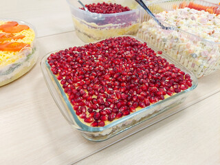 Salad with pomegranate, mushrooms and cheese in a glass plate on the festive table. mobile photo