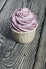 Cupcakes with cream and mascarpone. On pine boards. Close-up.