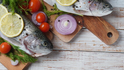 Fresh trout on a table with lemon, pepper and dill. Tasty fish ready for cooking. Healthy seafood and dieting concept.