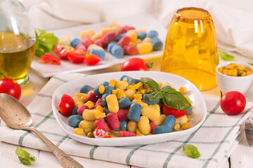 Colored gnocchi with vegetables and sweet corn.