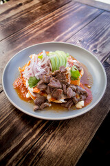 Delicious Mexican breakfast of red chilaquiles with grilled flank steak