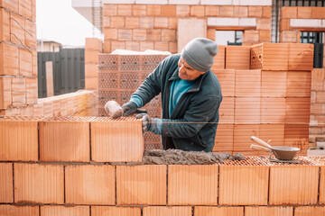 Portrait of professional construction worker, mason, bricklayer building walls