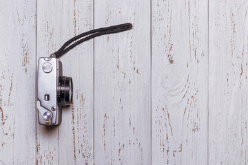 Old retro camera with a strap on the table