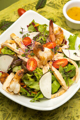 Chicken and shrimp salad with apple on green background