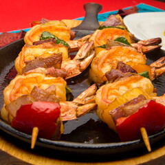 Gourmet shrimp skewers with green, red and yellow bell peppers