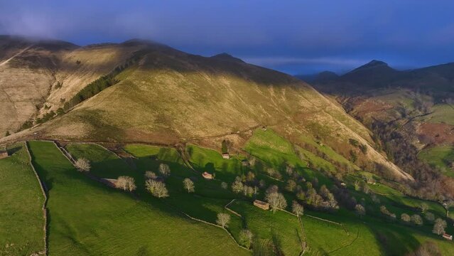 Winter landscape of meadows and cabins from Pas seen from a drone. Pasiegos Valleys between Selaya and San Roque de Riomiera. Cantabria, Spain, Europe