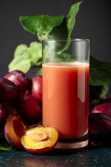 Plum juice and fresh purple plums.