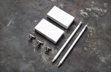 Blank stationery set. White business cards and pencils on concrete background.