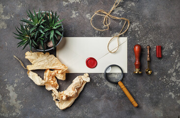 Photo of blank vintage envelope and retro stationery on concrete background. Flat lay.
