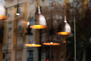 Spotlights with incandescent bulbs creating a warm atmosphere inside a restaurant.