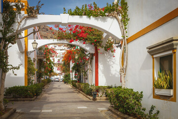 Fototapeta premium Street with bougainvillea flowers in Puerto Mogan, Gran Canaria island, Spain
