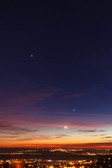 Crescent young Moon and planets on colorful sky.
