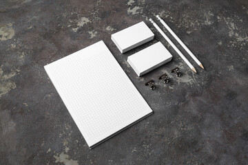 Photo of blank stationery set on concrete background. Copybook, business cards and pencils. Corporate identity template. Responsive design mockup.