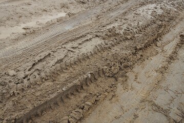 brown texture from a car trail of wet clay and ground on the road