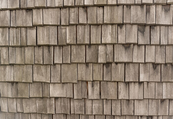 Tiles made of wood for the roof. The surface is laid in even rows. weathered old texture material....