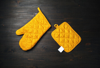Oven mitt and potholder on wooden background. Kitchen accessory. Cooking mitten, oven-glove. Flat...