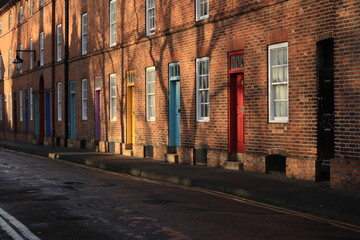 A row of old brick houses with colorful doors