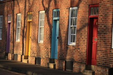 A row of old brick houses with colorful doors